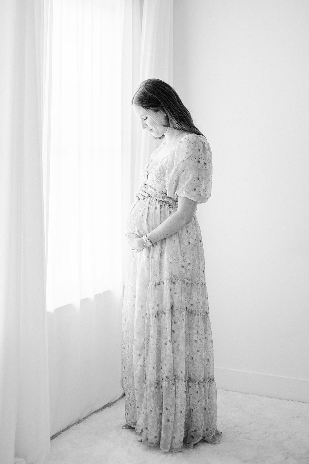 pregnant woman near window taken by memphis maternity photographer