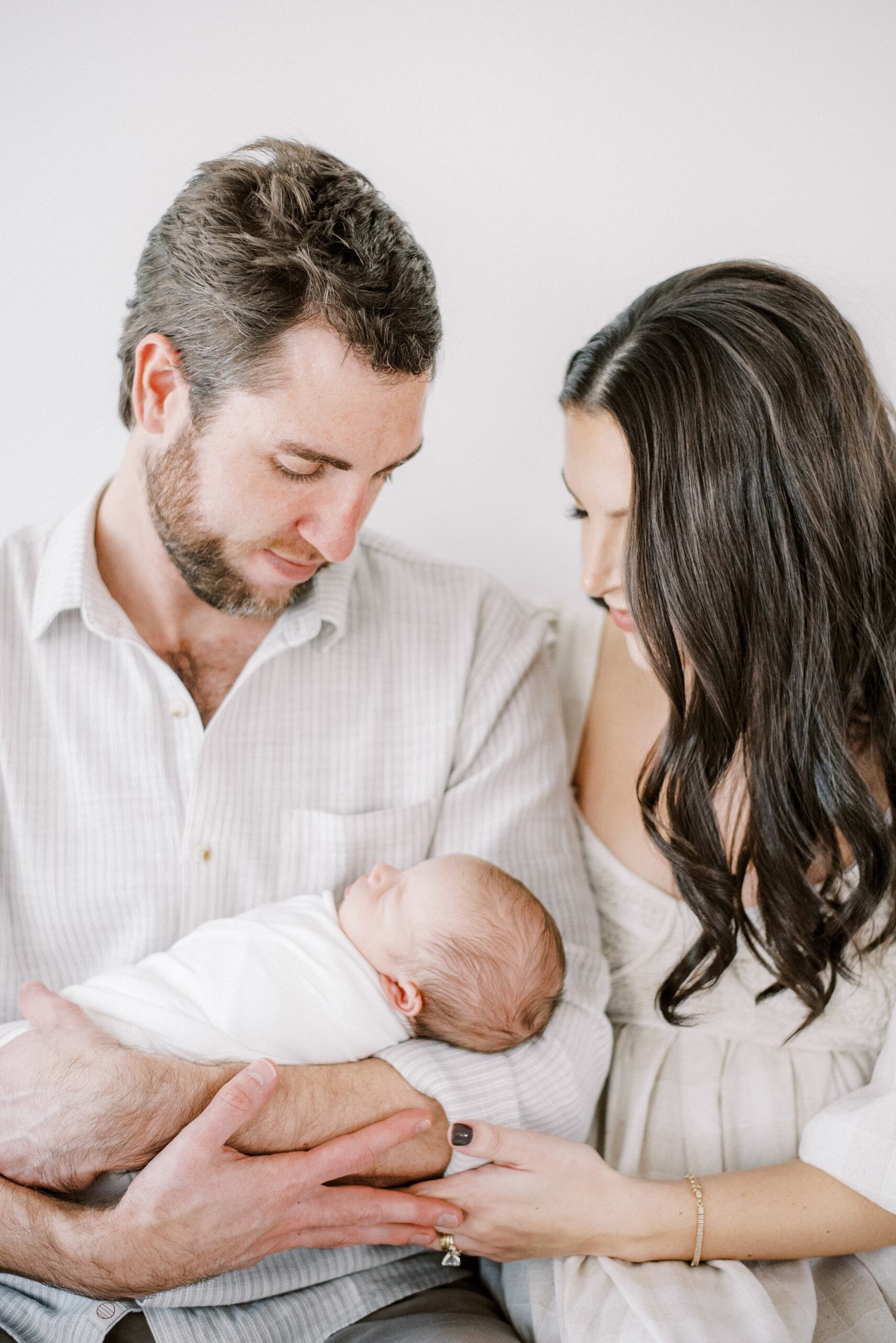 mom and dad holding newborn in memphis photography studio